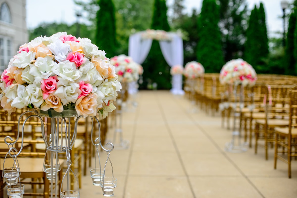 An outdoor event set up with flowers and rows of chairs before doors open